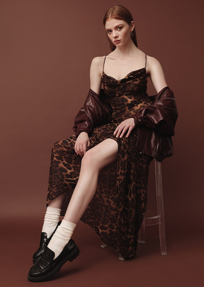 Camryn seated in a patterned slip against a dark studio backdrop