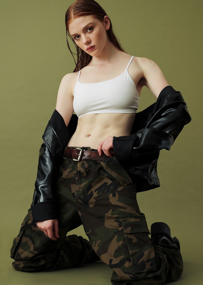 Camryn in a sporty fashion look against an olive backdrop